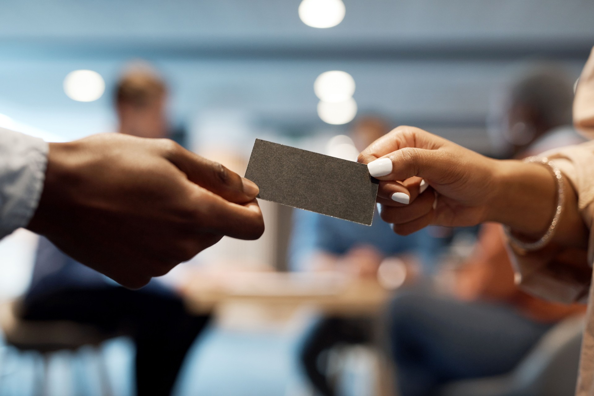 Shot of two businesspeople exchanging business cards at a conference